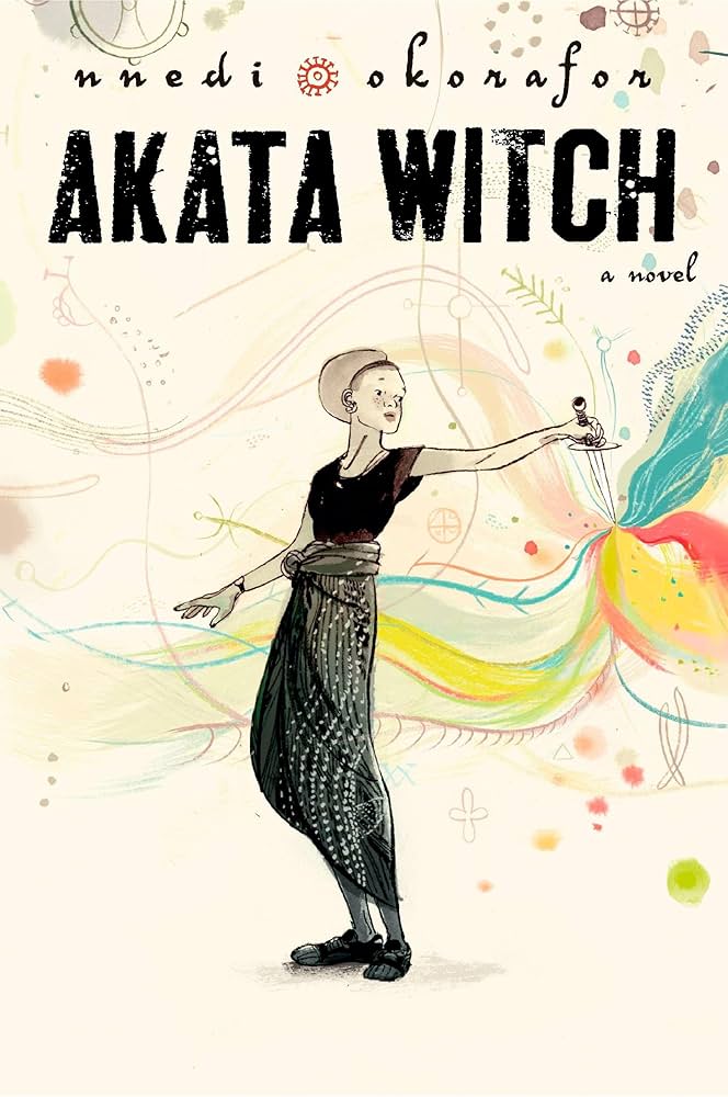 Akata Witch cover: an albino African girl holds out a dagger. Color seeps from its point in the abstracted shape of a flower.