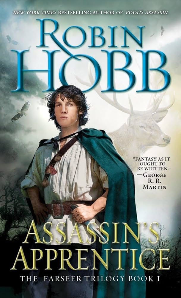 Assassin's Apprentice cover: a boy in a blue cloak clutches a dagger at his waist, a buck visible behind him in the mist.
